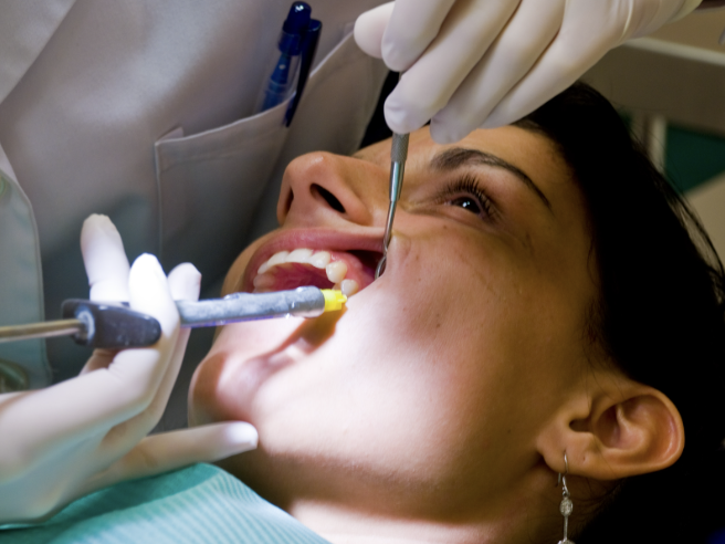 Paciente Tocándose Suavemente La Mejilla Después De Recibir Anestesia Local Durante Un Tratamiento Dental